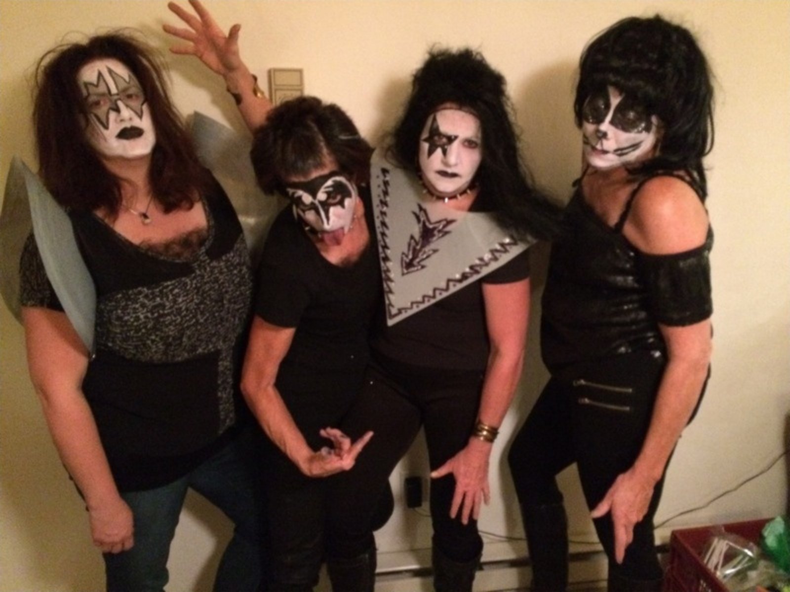 Four adults in KISS-inspired rock band face painting by Annie McInnes of About Face Painting, Denver