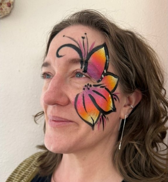 Hibiscus face painting design for Easter and spring events by About Face Painting, Denver